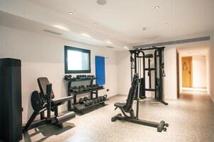 A gym with weight machines, dumbbells, and a pull-up bar.
