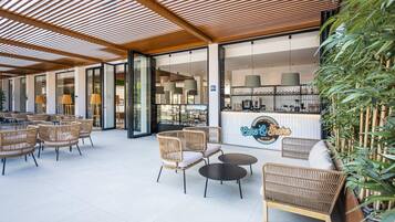 Un grand espace extérieur aménagé avec des meubles en osier et un comptoir de bar.