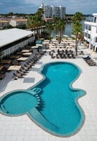 Una piscina al aire libre, sombrillas, sillones reclinables de piscina