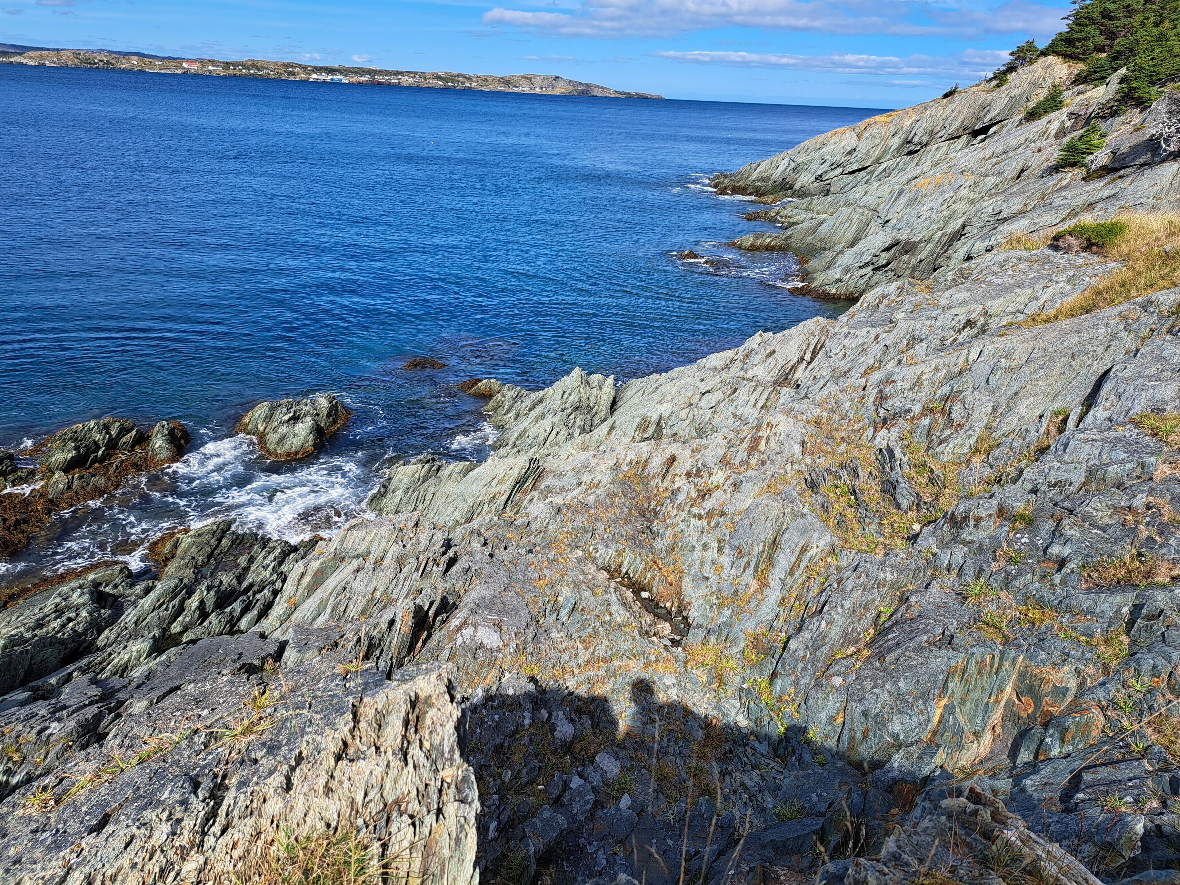 A coastal landscape with rocky terrain and a view of the sea.