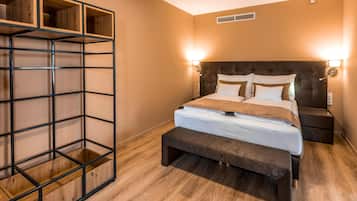 Une chambre à coucher comprenant un lit, des tables de chevet, un banc et une étagère.