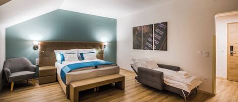 Une chambre moderne avec un grand lit, une table de chevet, une chaise et un canapé.