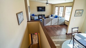 A spacious living area with a sofa set, a flat-screen TV, and a ceiling fan. - 24 Quiver Circle · Spectacular Mountain View ★ 5 Acres ★ PIKES PEAK (Florissant)