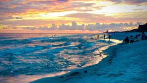 Ein Strand mit Wellen und einem Sonnenuntergang.
