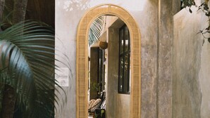 A small, enclosed space with a mirror, a potted plant, and a concrete wall. - Refugio Lodge (Tamarindo)