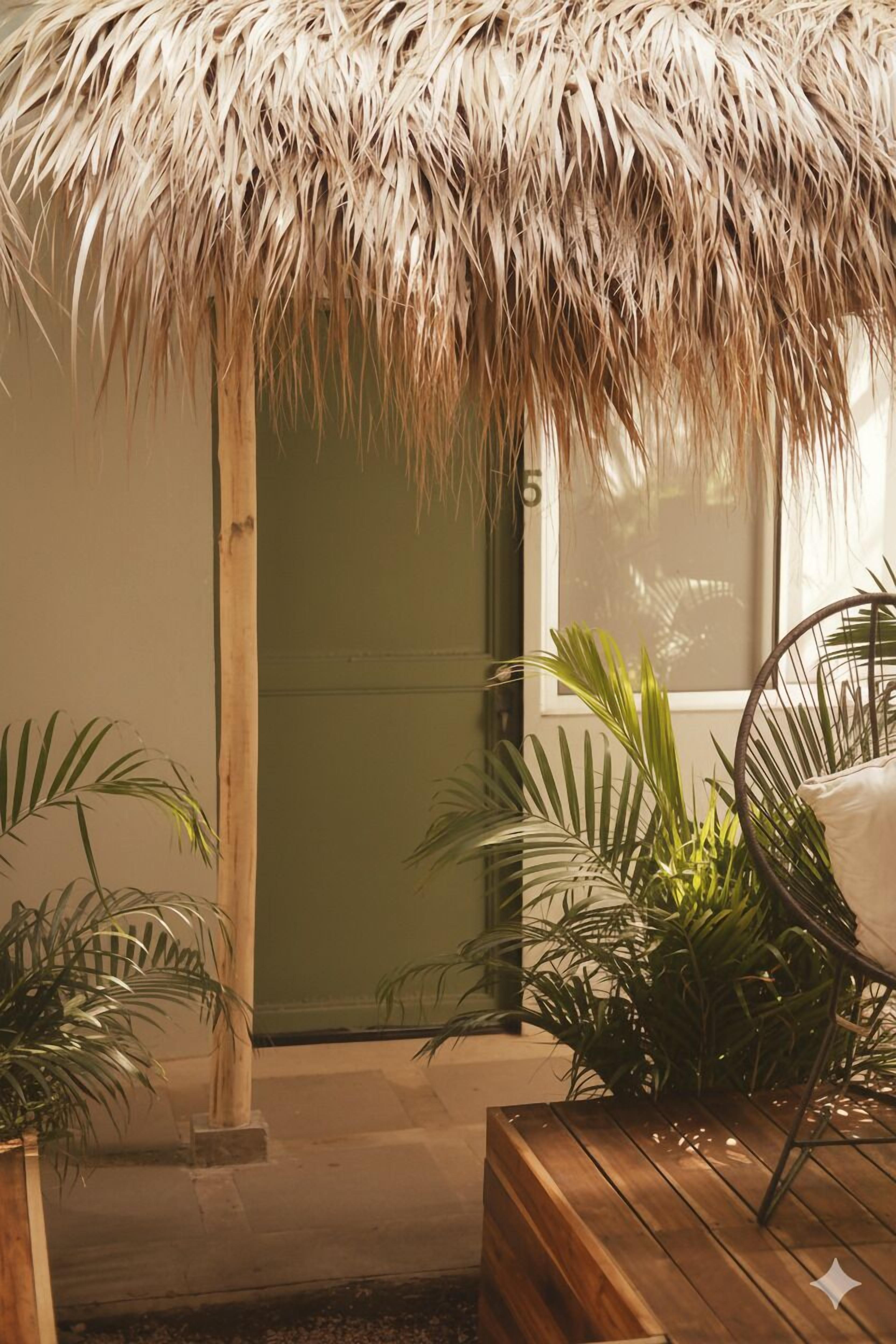 A room with a wooden bench, a chair, and a thatched roof structure.