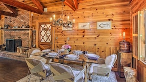 A wooden interior with a dining table set for six, surrounded by wicker chairs. - 1 Mi to Rainbow Lake: Lakeside Cabin w/ Deck! (Lakeside)