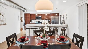 Une cuisine moderne dotée d’un îlot central, de meubles en bois et d’appareils électroménagers en acier inoxydable.