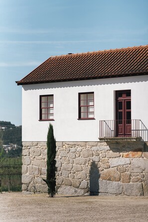 A two-story building with a stone base and a tiled roof. - Quinta da Corredoura Hotel Rural (Guimarães)