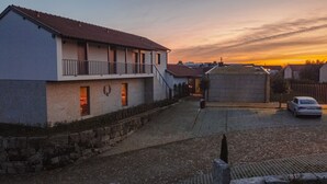 A two-story building with a balcony, a stone wall, and a paved driveway. - Quinta da Corredoura Hotel Rural (Guimarães)