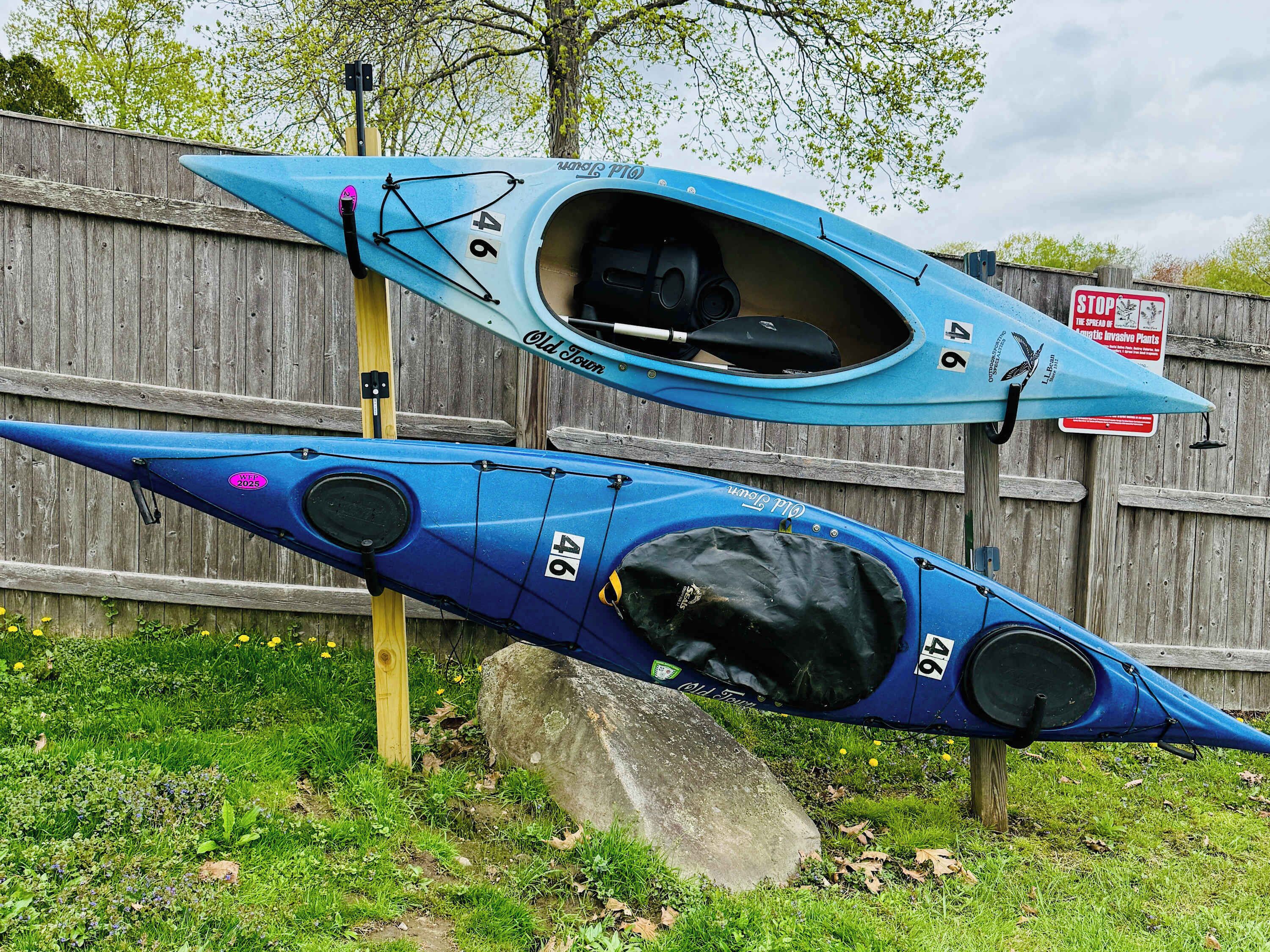 Deux kayaks portant le numéro 46, l’un étant posé sur un poteau en bois et l’autre sur le sol.
