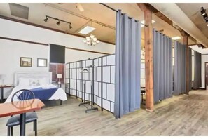 Experience a serene retreat with a traditional Japanese-inspired bed, wooden floor, and expansive window offering a view of the outdoors.