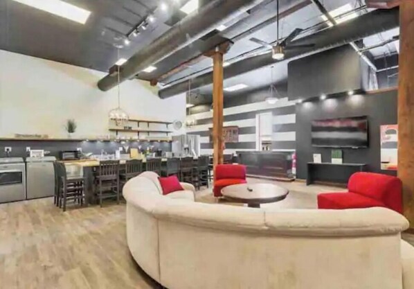 Relax in this open-plan living space with a curved sofa, dining area, and fully equipped kitchen.