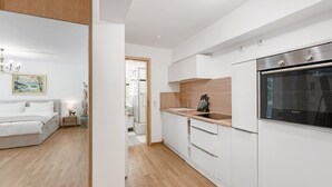 Une cuisine moderne avec des meubles blancs, un plan de travail en bois et un four Siemens.