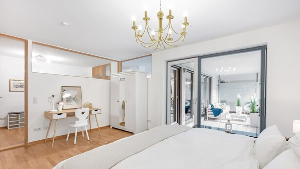 Une chambre moderne avec un grand lit, un bureau, une chaise et un grand miroir.