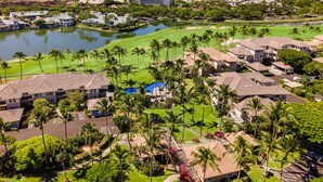 Een resort met meerdere gebouwen, een golfbaan en een waterpartij.