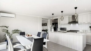 A modern kitchen with white cabinetry, a central island, and pendant lighting.