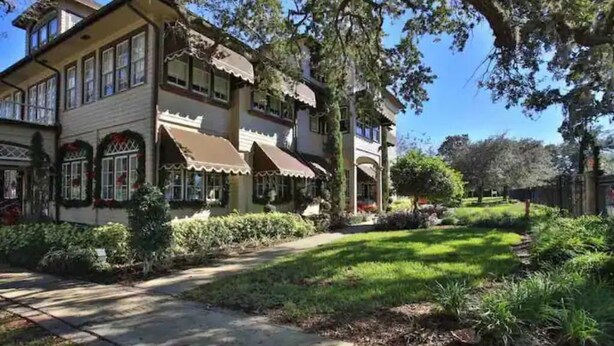 A two-story house with a front porch, a driveway, and a well-maintained garden. - Cute Beach House half a block from the beach 🏝 (Ormond Beach)