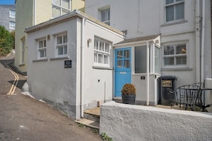 A two-story building with a blue door and a small garden area with a potted plant. - Beautiful Cottage Minutes from Mevagissey Harbour (Saint Austell)