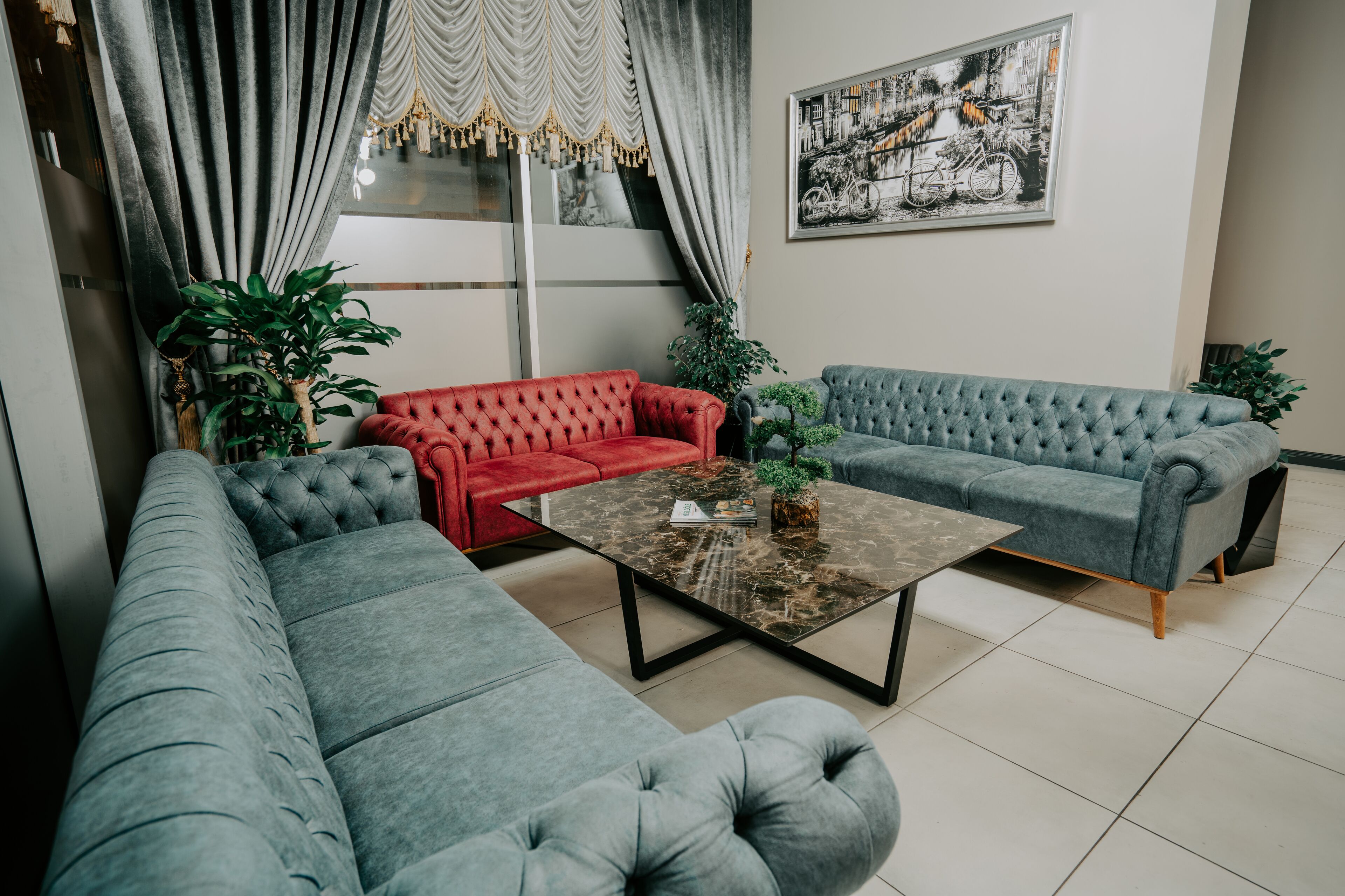 Un salon moderne avec des canapés gris, un canapé rouge et une table basse en marbre.