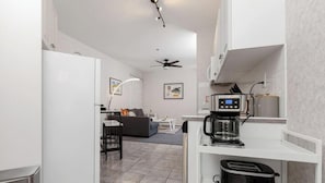 A compact kitchen with a coffee maker, toaster, and a small refrigerator.