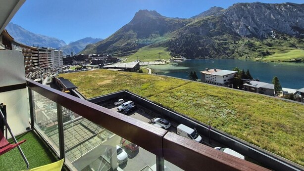 A balcony with a view of a lake, mountains, and a parking area. - 150m from resort center, 3rd floor, view lake, balcony, tv, ski locker, 40m², Tignes (Tignes)
