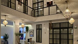 A spacious indoor area with a central pool, a second-floor balcony, and multiple hanging light fixtures. - Riad Nolita & Spa Kasbah (Marrakech)
