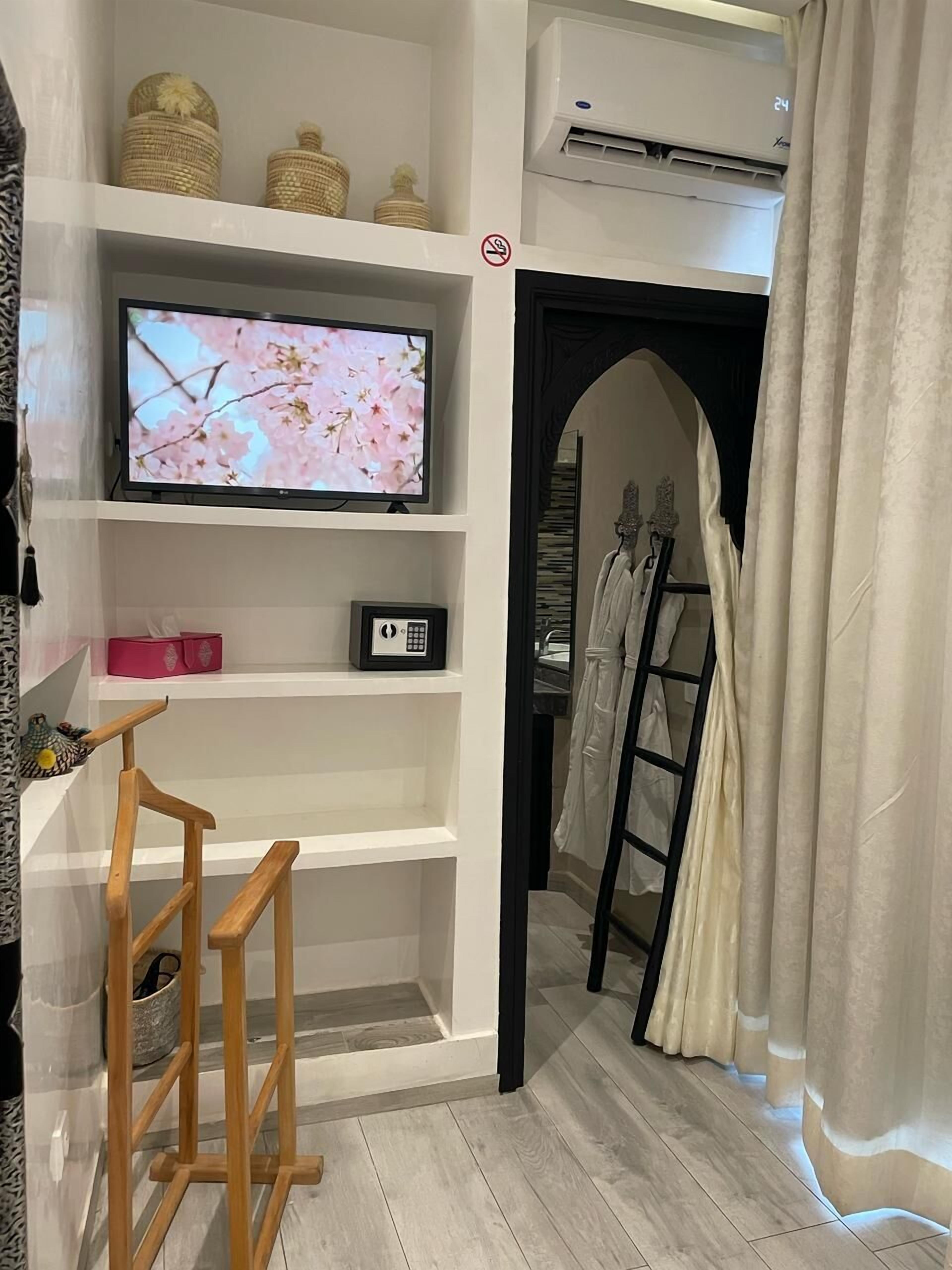Een kamer met een televisie op een plank, een ladder en een airconditioning.