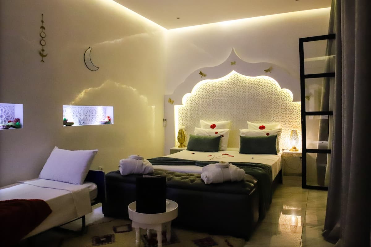 Une chambre d’hôtel avec un lit, un canapé, une petite table et un mur décoratif.