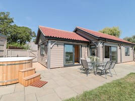 Una casa con un patio, un jacuzzi y una zona de estar cubierta al aire libre.