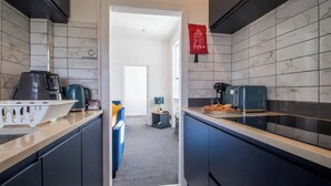 A modern kitchen with dark cabinetry, a coffee machine, and a kettle. - Bella House Fresh 3 Bed Apt in Glasgow  Sleeps 5 (Glasgow City)