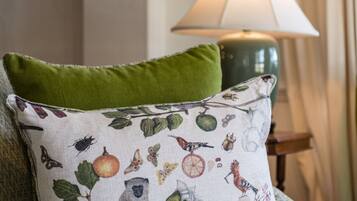 A sofa with a patterned pillow and a green accent pillow.