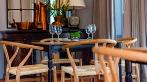 A dining table with four chairs, a lamp, and a vase with plants. - Fairview House (Keurboomstrand)