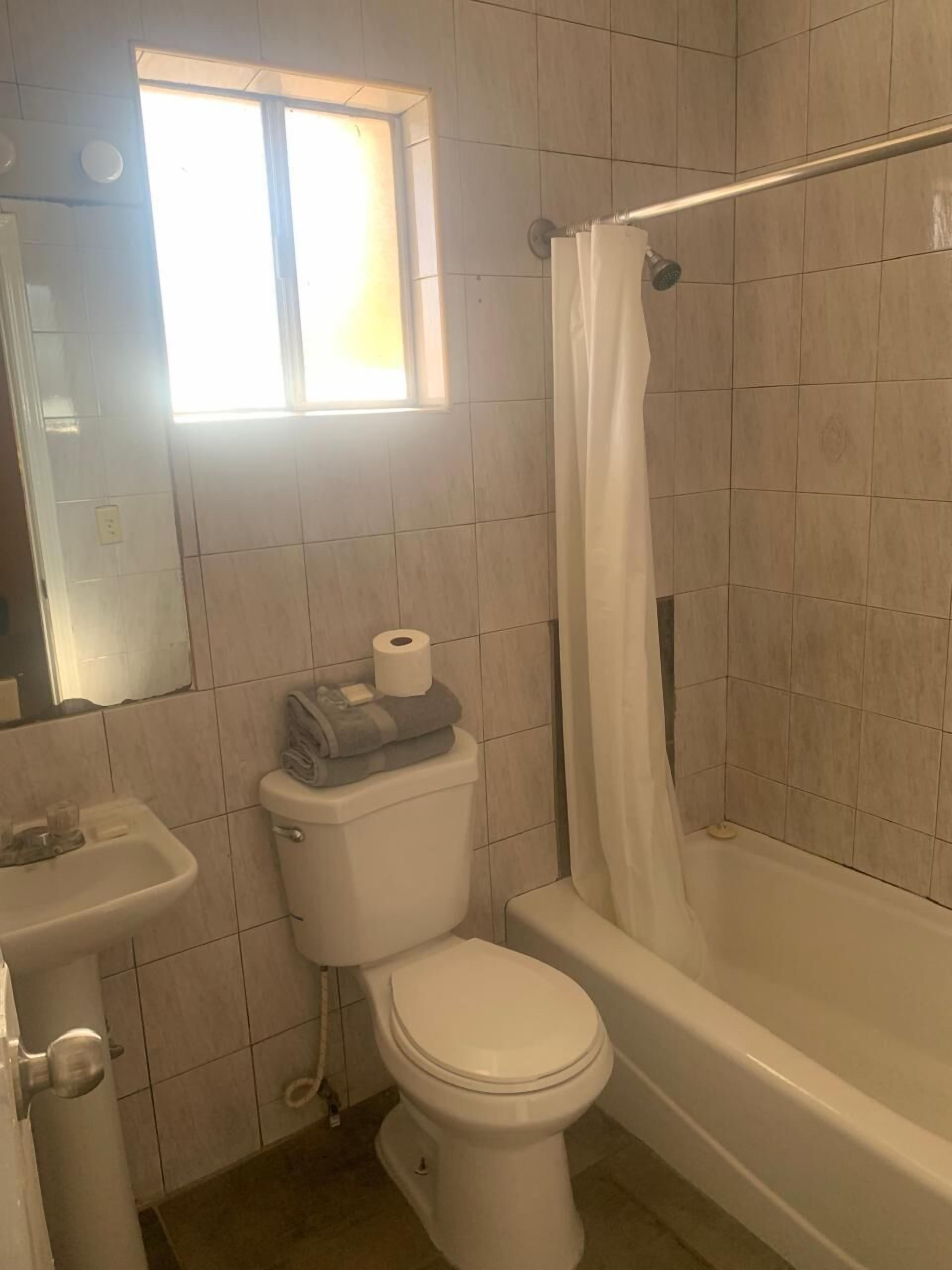 Une salle de bain équipée de toilettes, d’un lavabo et d’une baignoire.