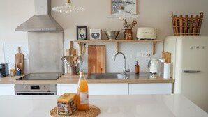 A modern kitchen with a stainless steel range hood, wooden countertops, a vintage Smeg refrigerator, and a variety of kitchen utensils and appliances. - Les Hirondelles, beautiful house with garden for 7 people (Saint-Valery-sur-Somme)