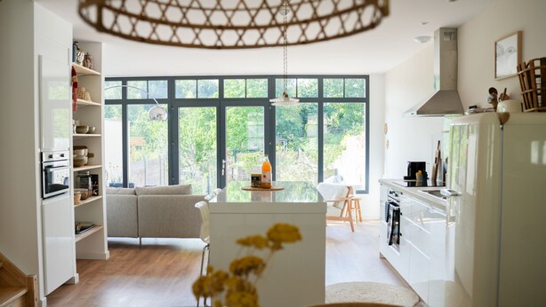 A modern kitchen with white cabinetry, a dining area with a table and chairs, and large windows offering a view of greenery outside. - Les Hirondelles, beautiful house with garden for 7 people (Saint-Valery-sur-Somme)