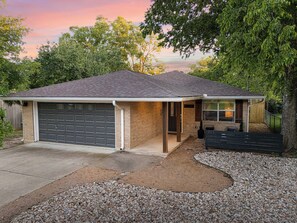 A single-story house with a garage, a front porch, and a small patio area.