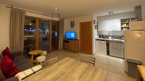 A modern apartment with a living room, dining area, and kitchen. - Charming T3 in a residence close to the slopes and shops South-facing balcony (La joue du loup)