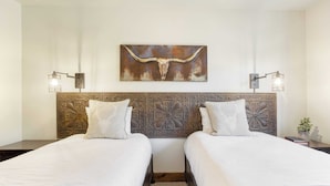 A hotel room with two beds, a decorative wall art of a bull's head, and two wall-mounted lamps. - Snow King by Avantstay Close to the Slopes w/ Hot Tub! (Park City)