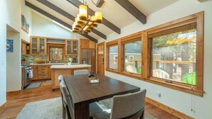 Une cuisine spacieuse avec des meubles en bois, un îlot central et une grande fenêtre donnant sur l’extérieur.