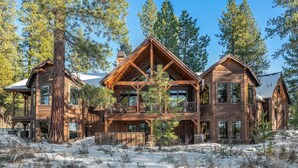 A large wooden cabin with multiple levels and balconies, surrounded by snow and pine trees. - Big Pine by Avantstay Stunning Secluded Oregon Home w/ Hot Tub (Bend)