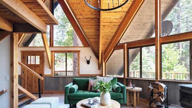 A spacious loft-style room with a large green sofa, a round coffee table, and a fireplace. - Timberline by Avantstay Stunning Chalet Cabin w/ Hot Tub, Pool Table & Home Theater! (Carnelian Bay)