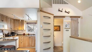 A modern kitchen with wooden cabinets, a microwave, and a dining area with a glass table.