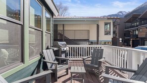 A deck with Adirondack chairs, a grill, and a view of mountains. - Pacific Street Townhome 514b by Avantstay Cute Townhouse in the Heart of Telluride! (Telluride)