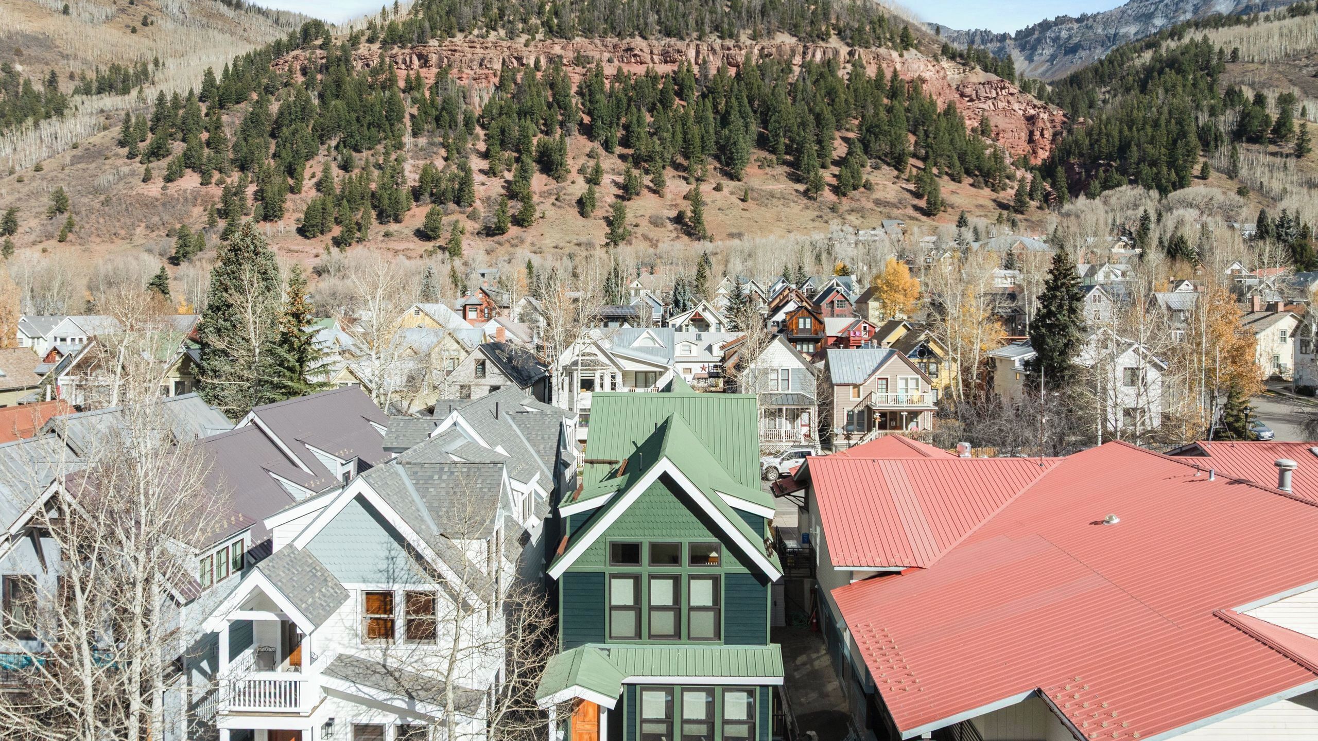 A residential area with houses, a mountain backdrop, and a clear sky.