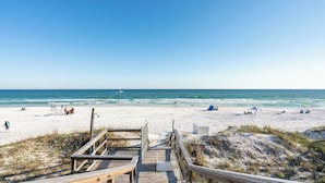 A beach with a wooden boardwalk leading to the shore, clear skies, and calm sea. - Promenade by Avantstay Beach Front Mansion w/ Breathtaking Views & Pool! (Miramar Beach)