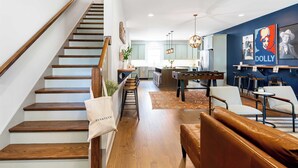 A modern interior with a wooden staircase, a pool table, and a cozy seating area. - Waverly by Avantstay Nashville-inspired Townhome w/ Luxury Kitchen, Pool Table (Nashville)