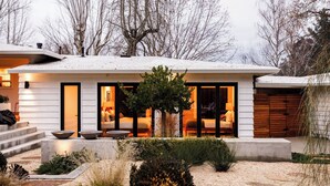 A modern house with a snow-covered roof, large windows, and a well-lit interior. - Marquee By Avantstay Modern Stylish Estate w/ Pool & Entertainers Courtyard (Sonoma)