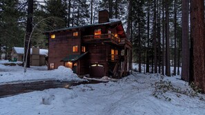 Une cabane rustique avec une façade en bois, un balcon et une cheminée.