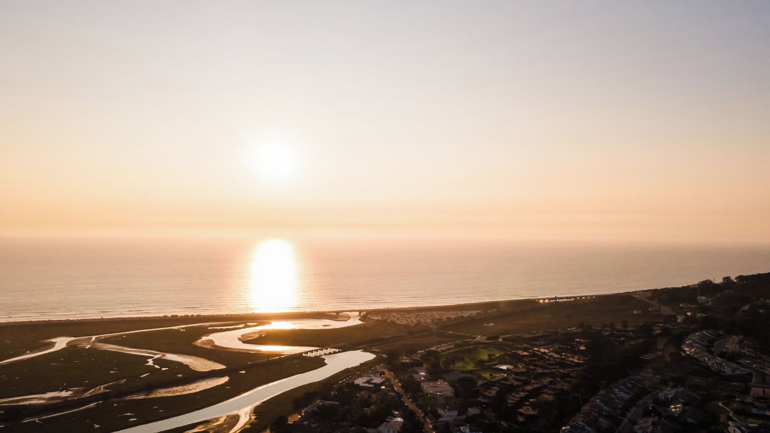A coastal landscape with a river, a bridge, and a town.